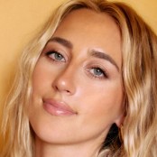 A close up image of a blonde woman with wavy hair
